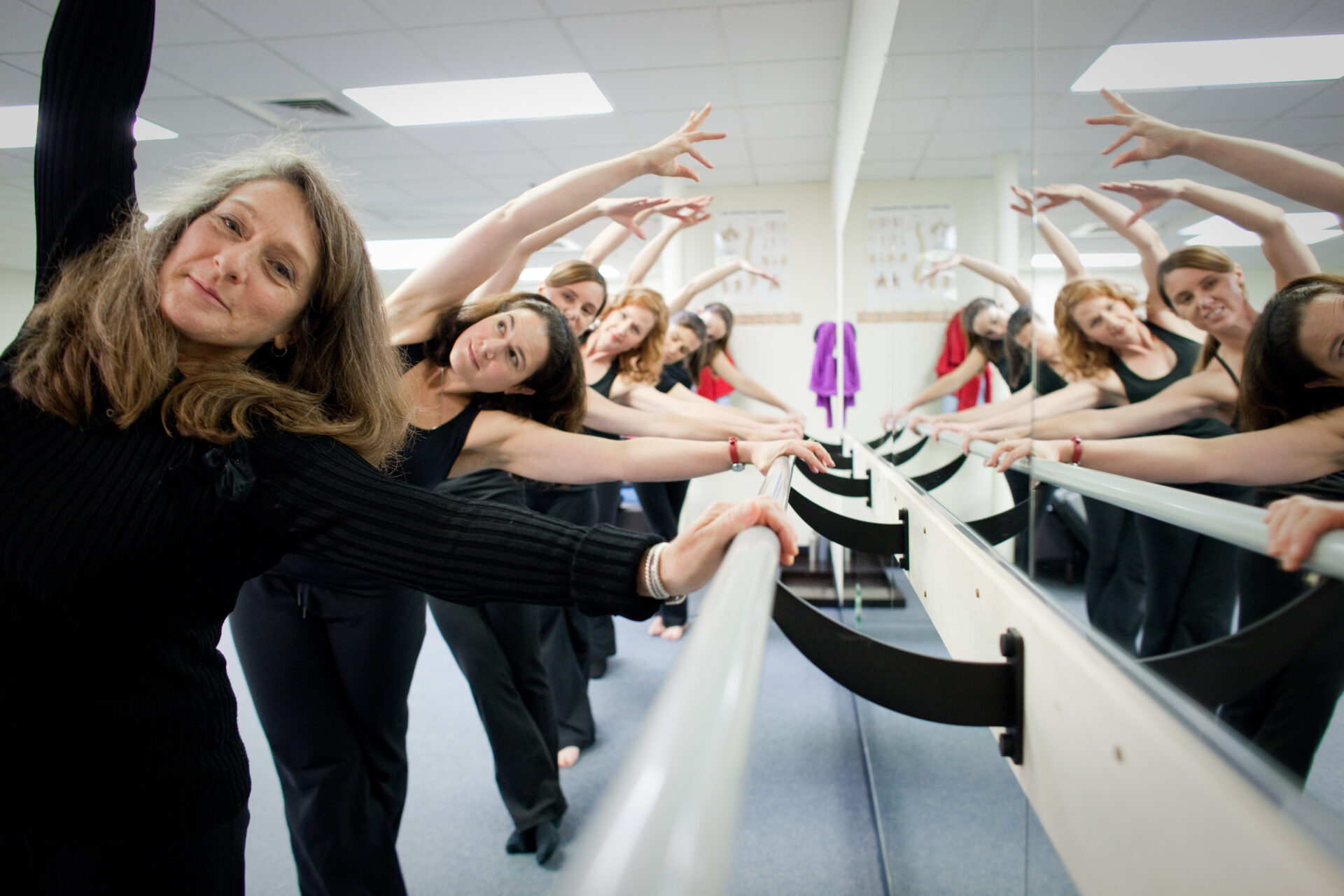 A group of women are doing different things in the mirror.