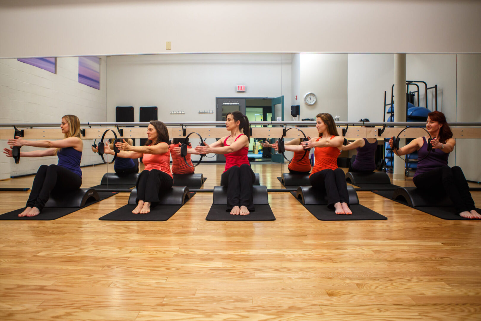 A group of women are doing yoga in the gym.