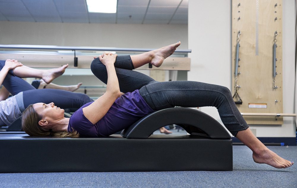 A woman is on the ground with her legs crossed.