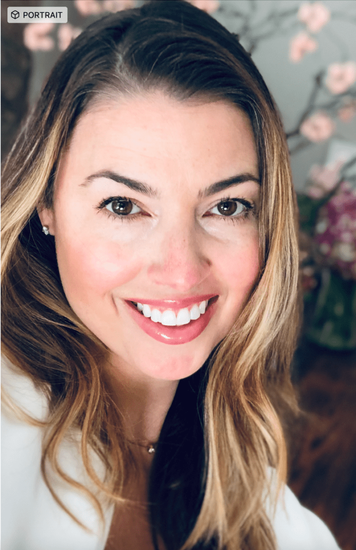 A woman with long hair smiles for the camera.