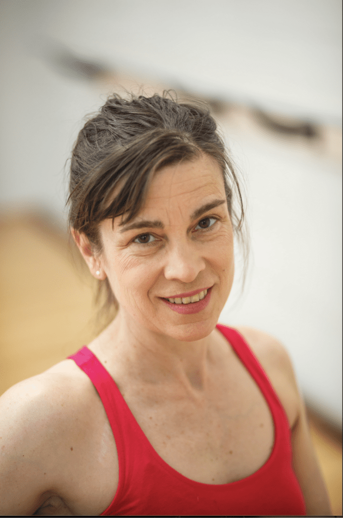 A woman in red tank top smiling for the camera.