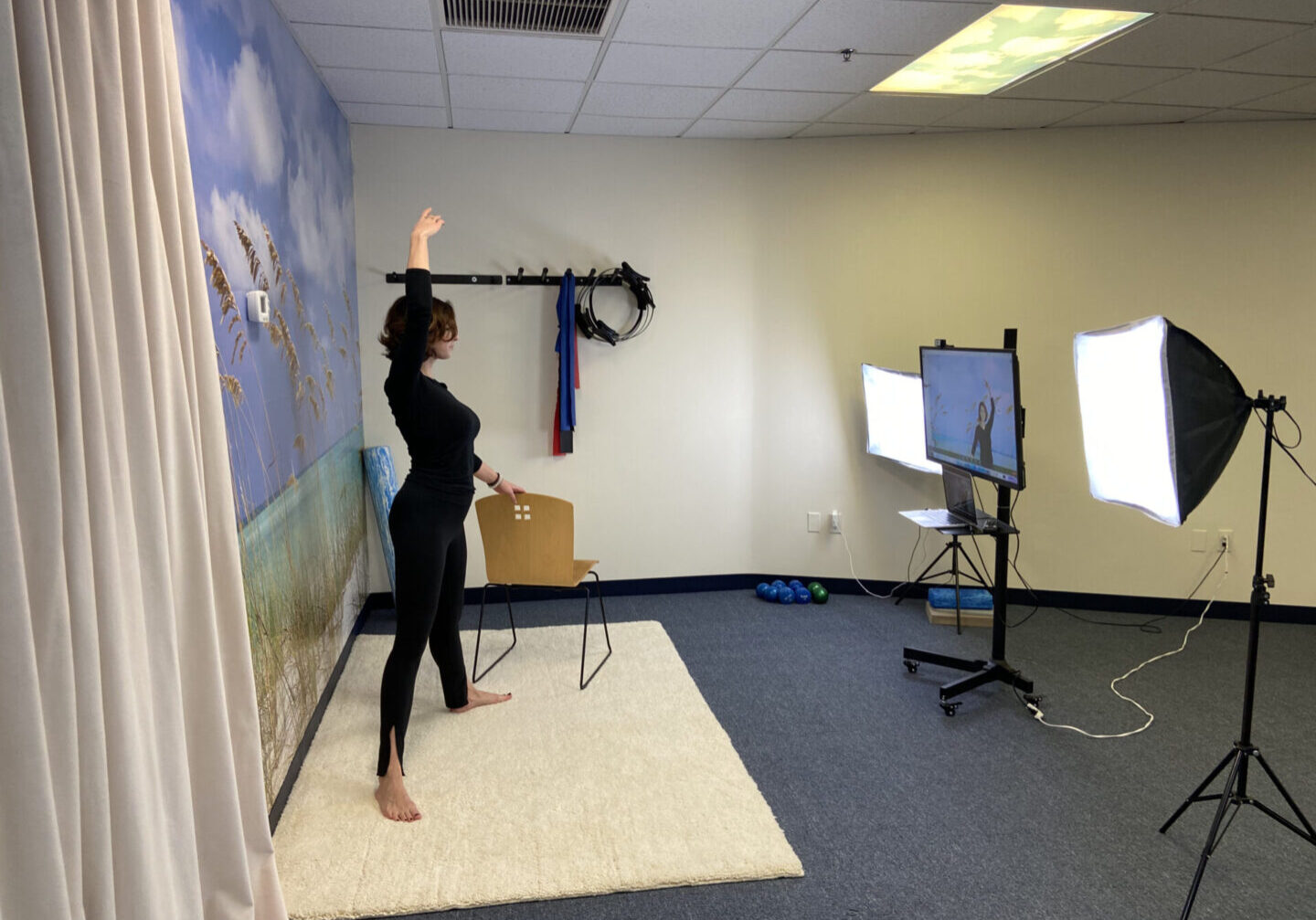 A woman standing in front of a tv holding something up to the air.